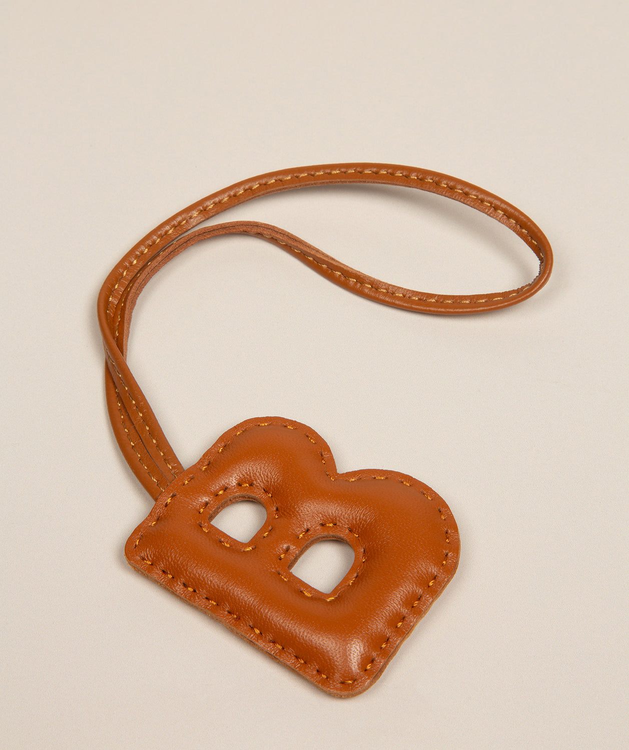 tan leather charm keyring side profile angle
