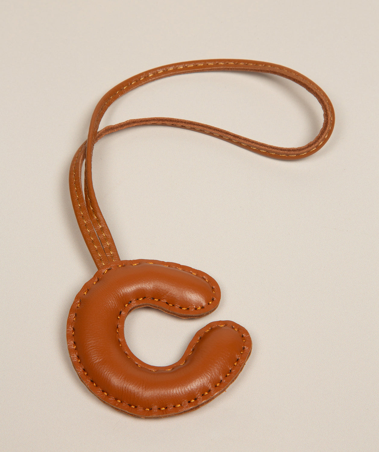 tan leather charm attachment loop and hardware detail