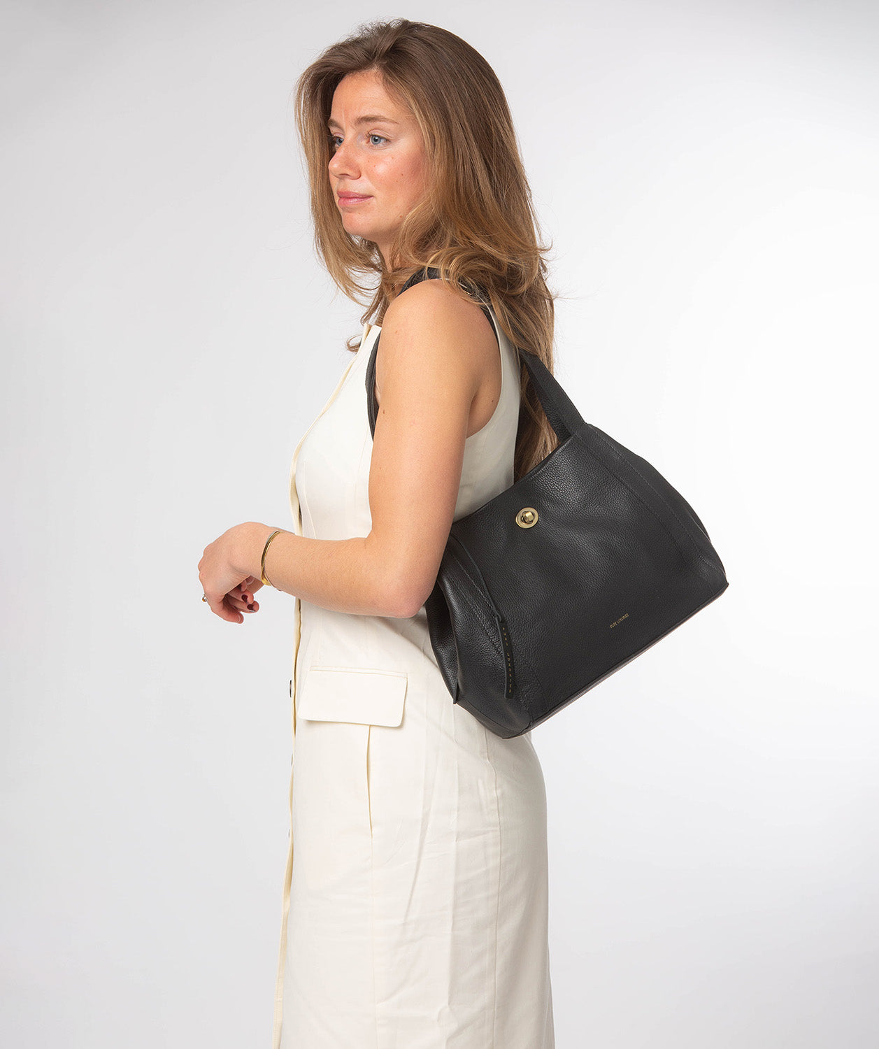 Side profile showing dual leather handles and structured silhouette