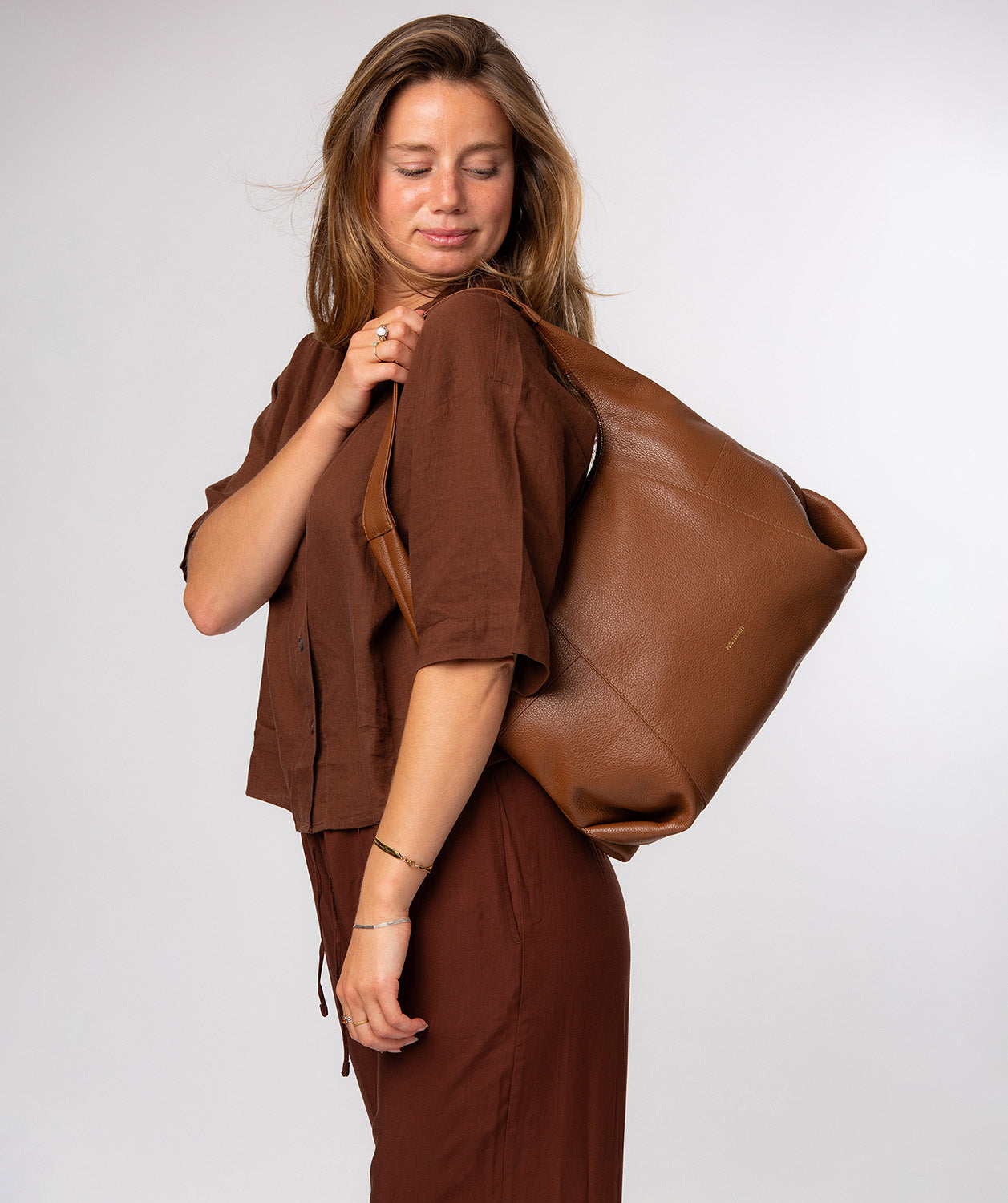 Shoulder bag crescent zip-top closure and gold foil logo