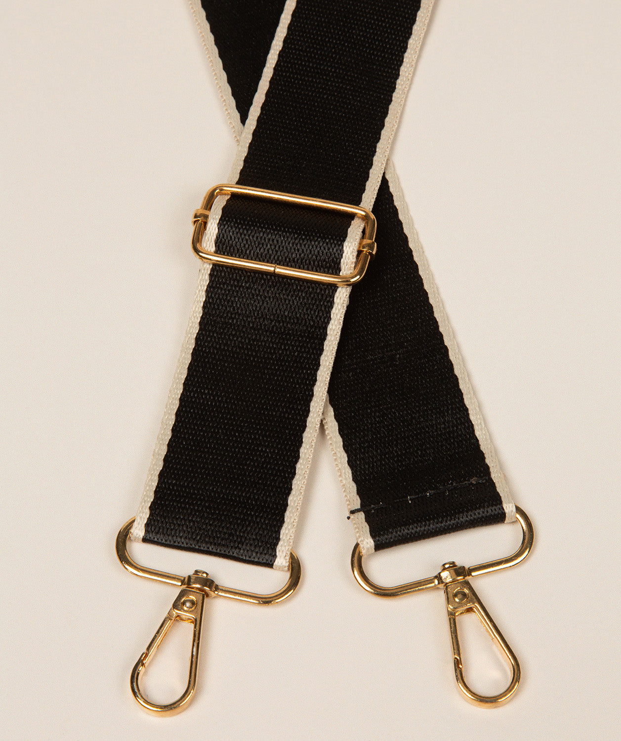Pure Luxuries black and beige adjustable bag strap with gold fittings front view