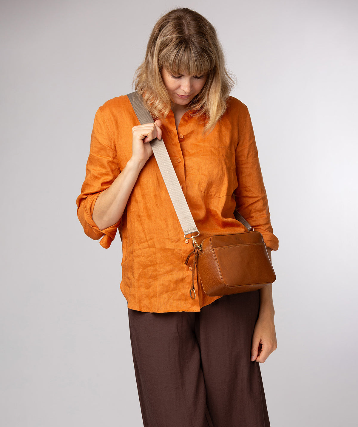Khaki bag strap gold hardware detail and attachment point