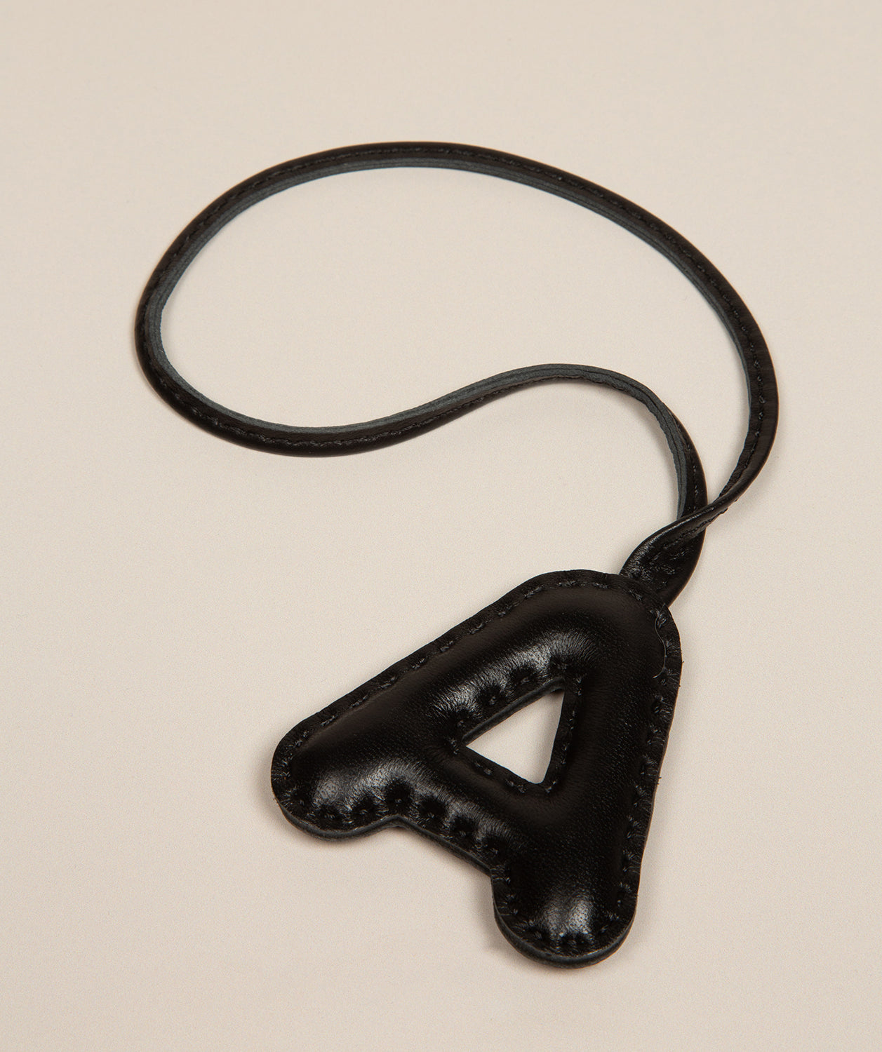 Pure Luxuries black leather letter charm with embossed A front view