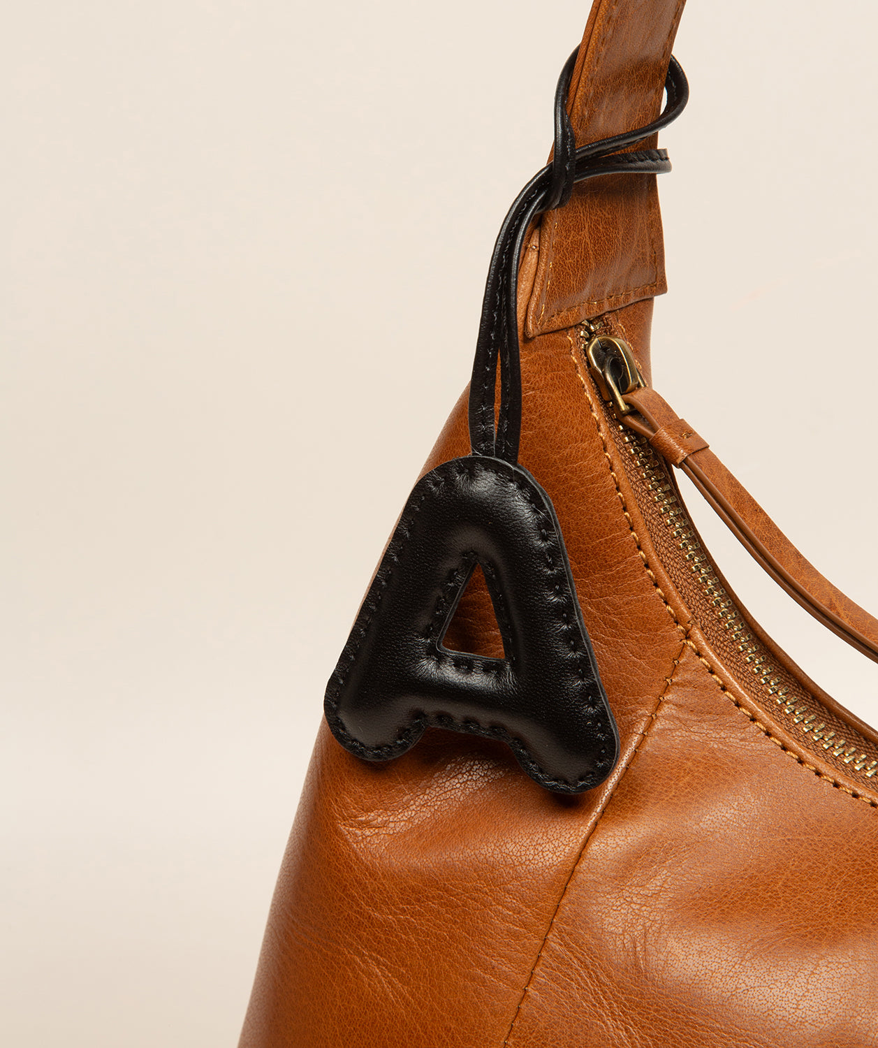 black leather letter charm pillow-like texture detail