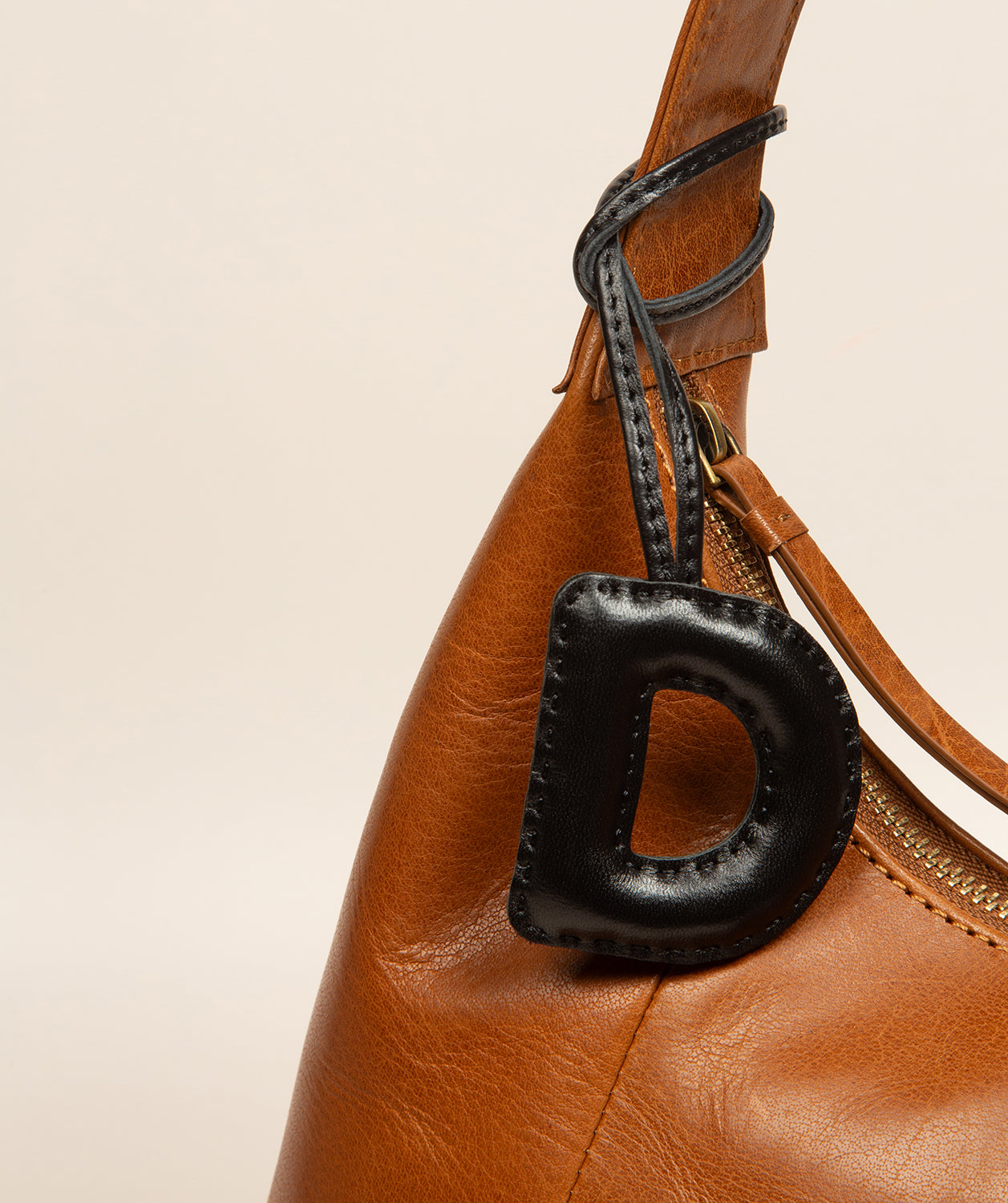 leather charm paired with bag strap attachment point