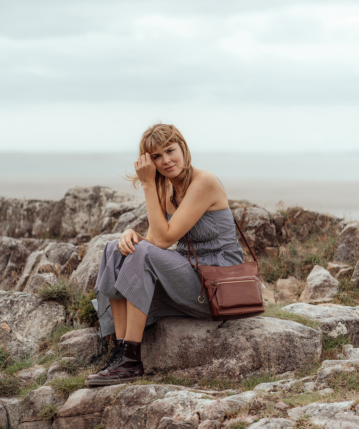 Lifestyle image woman wearing Conker Brown leather cross body bag