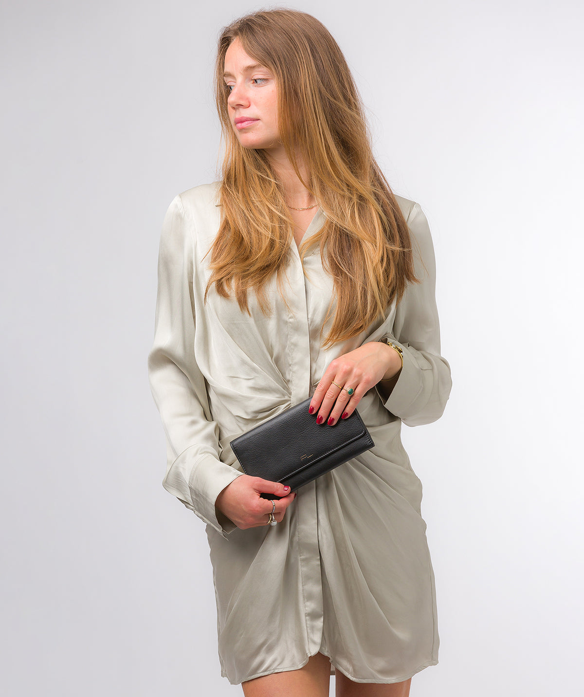 Clutch bag held under arm demonstrating versatile carry