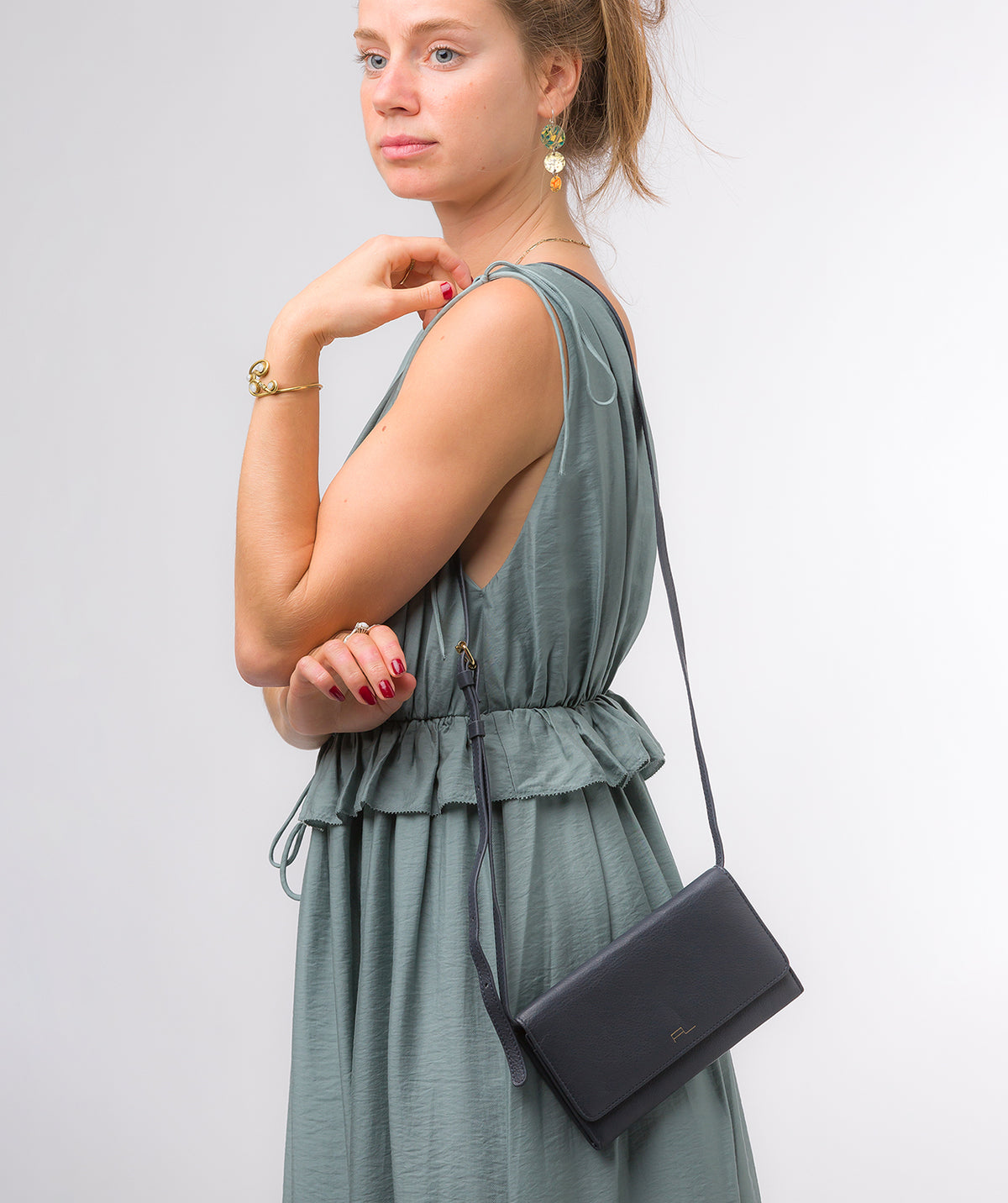 Navy leather clutch bag side profile with crossbody strap