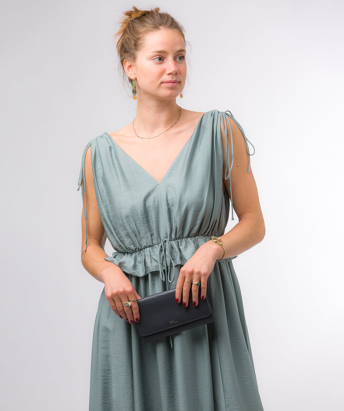 Navy clutch bag styled as both handheld clutch and crossbody