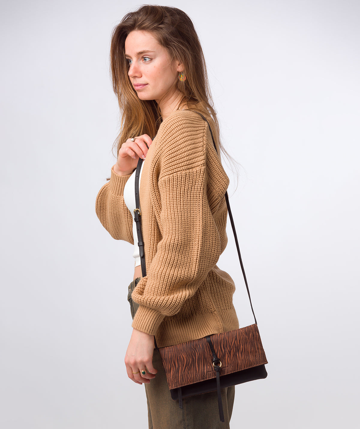 Fold-over magnetic closure and adjustable leather strap detail