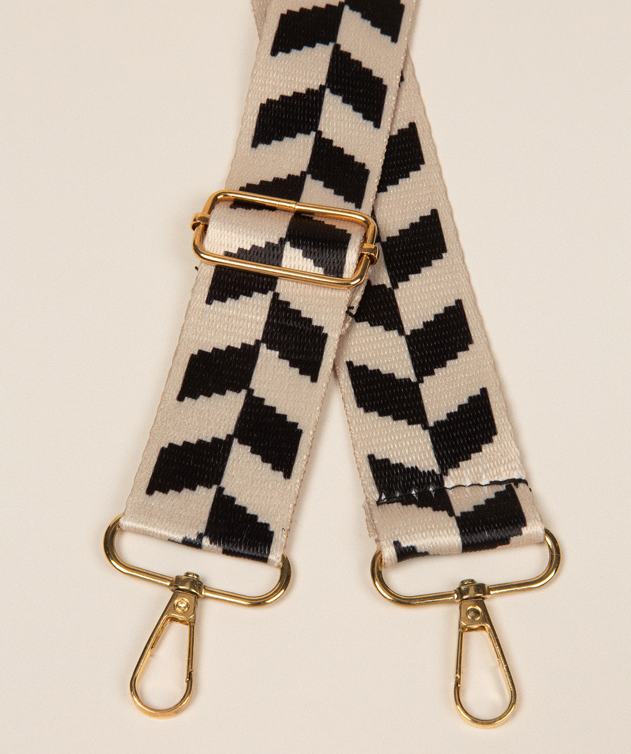 Pure Luxuries beige and black vine print bag strap with gold fittings front view
