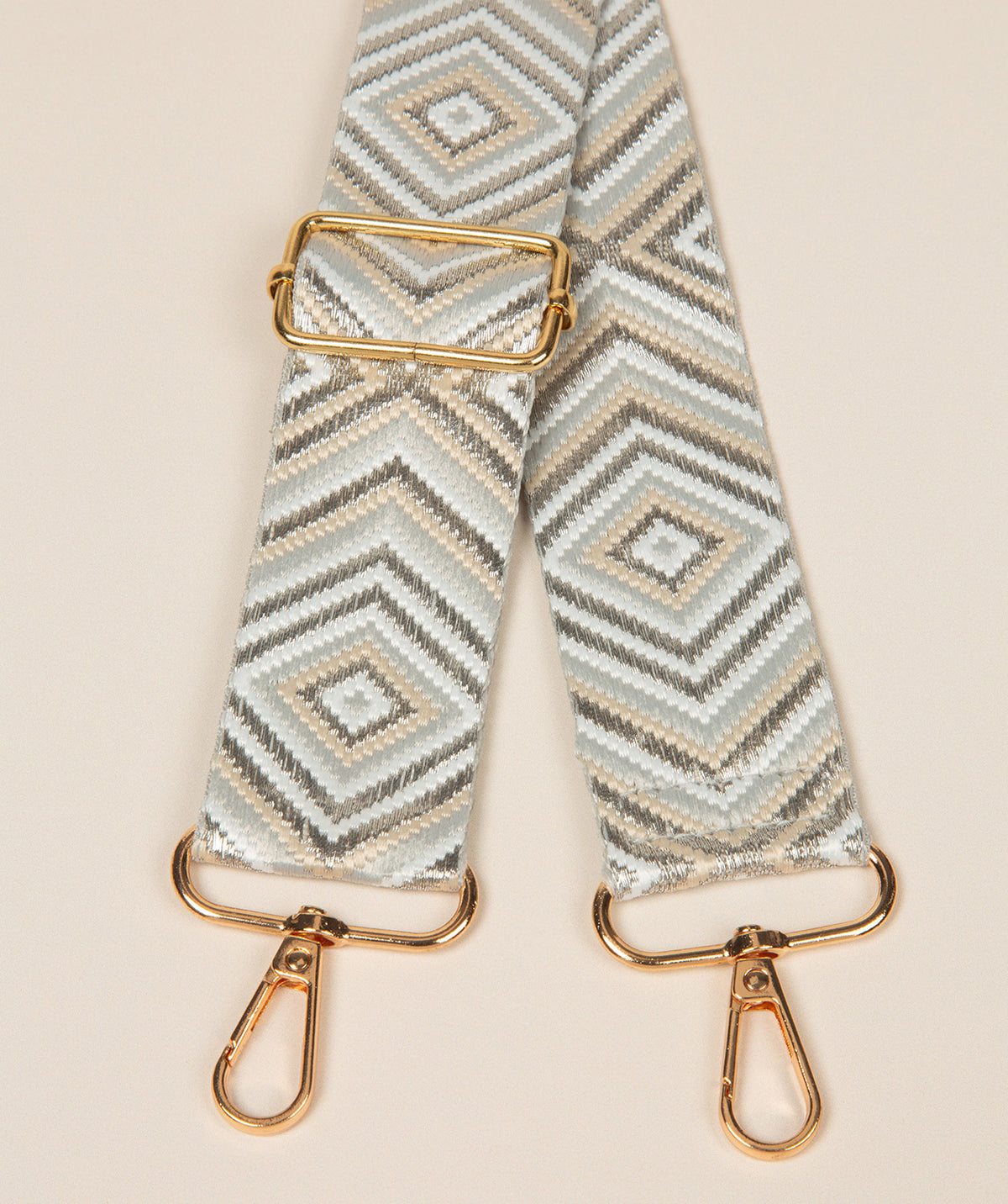 Pure Luxuries silver and white geometric bag strap with gold fittings front view
